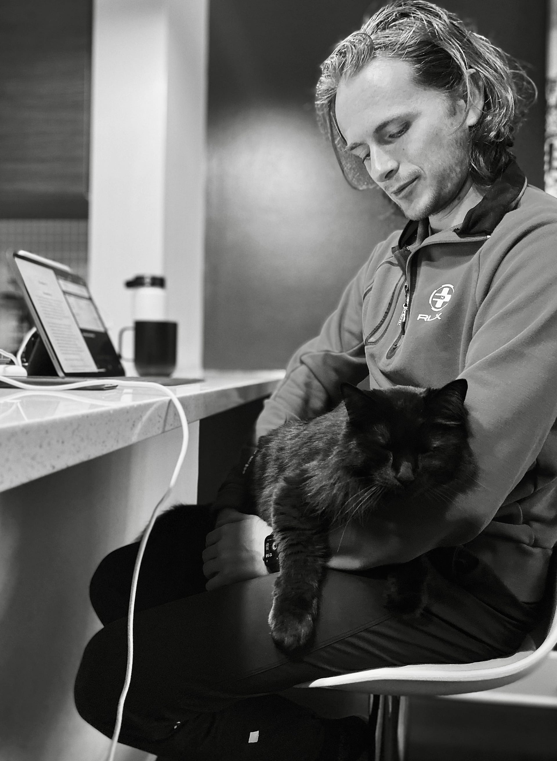Person sitting with a black cat.