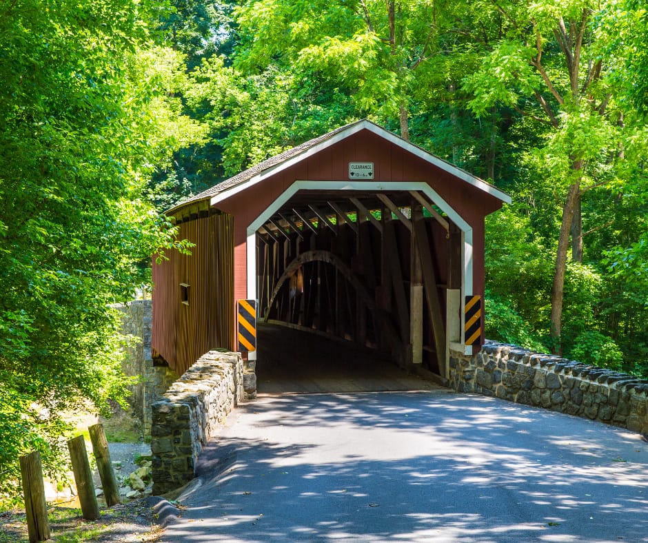 Red covered bridge in lush greenery